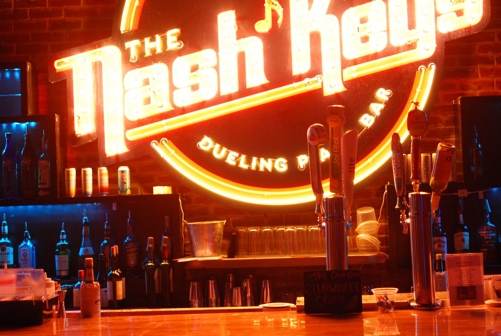 The Nash Keys neon sign glowing amber over the bar taps