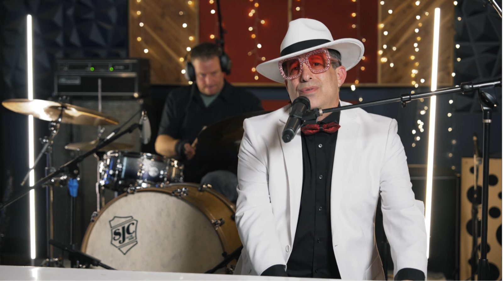 Showman in white suit and rhinestone glasses at the piano — live tribute night at The Nash Keys